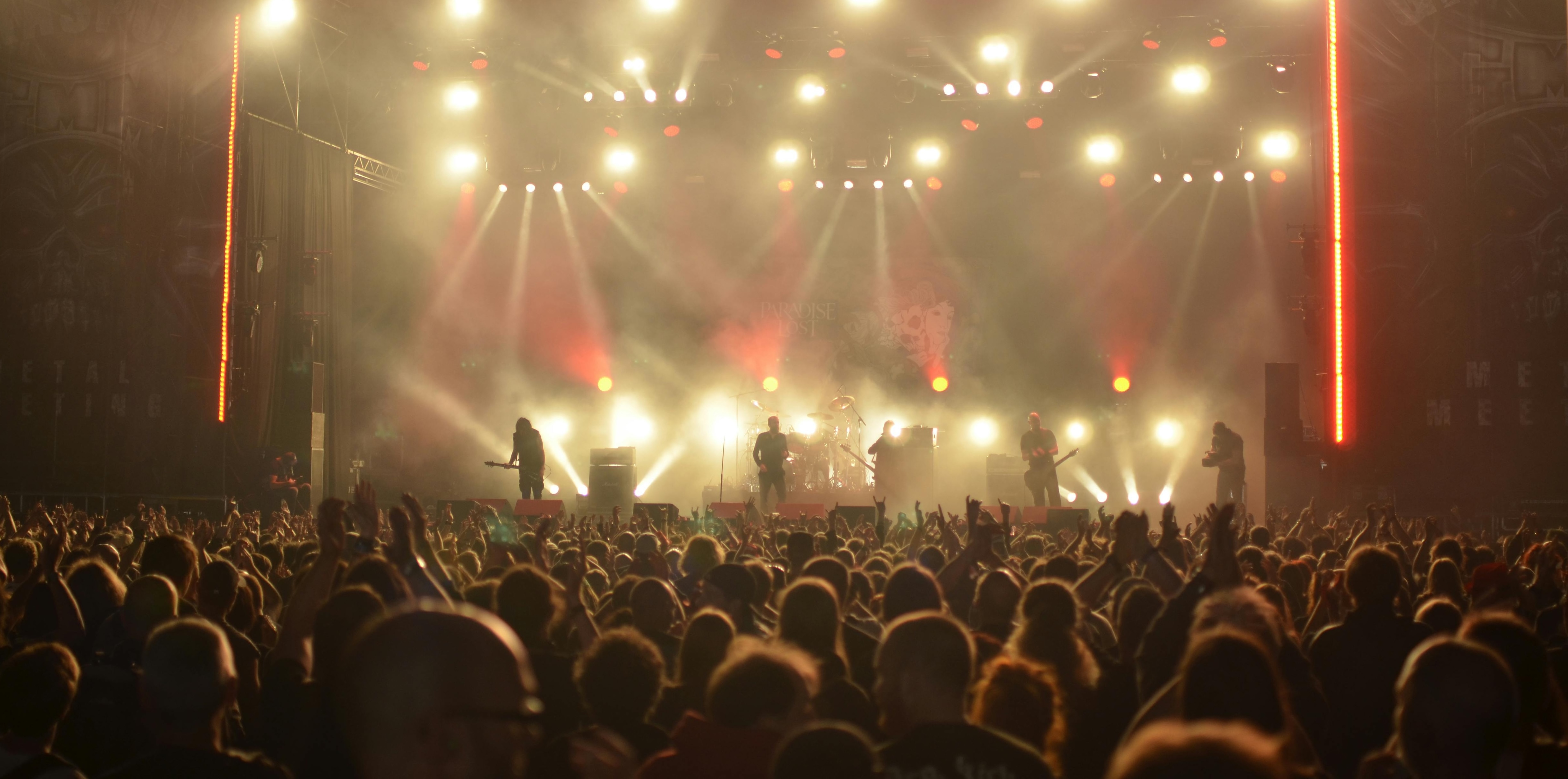 Full scale concert stage with lighting rig, live band, and crowd